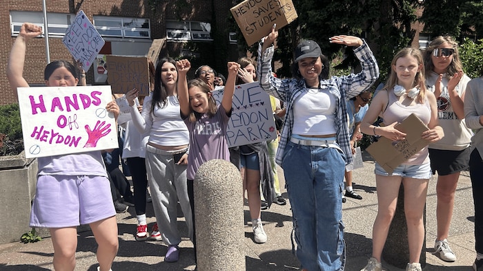 Des jeunes avec des pancartes.