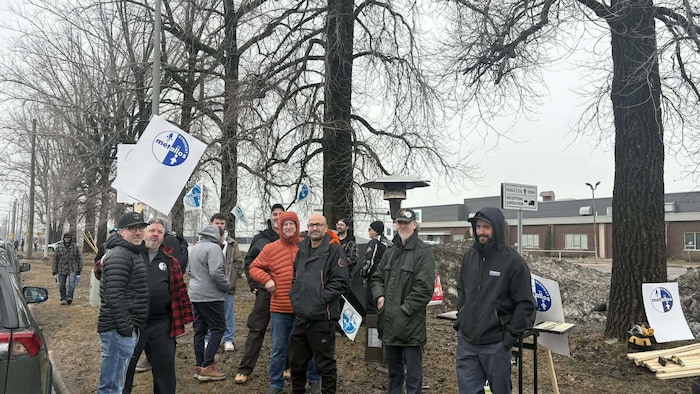 Des personnes manifestent avec des pancartes.