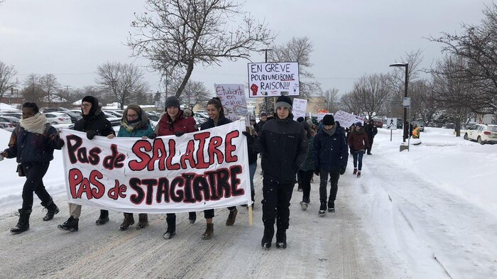 Des étudiants tiennent une banderole sur laquelle il est inscrit « Pas de salaire, pas de stagiaire »