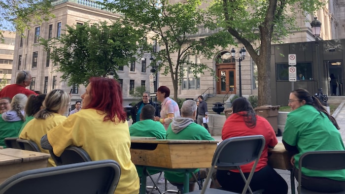 Des enseignants recréent une classe de 3e année devant l'entrée des députés à l'Assemblée nationale.