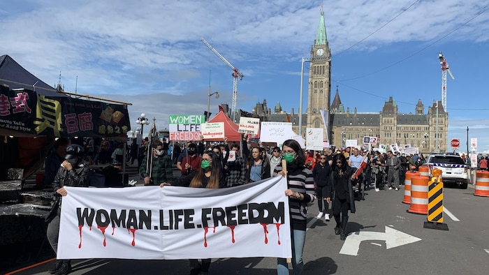 Manifestantes con una pancarta frente al Parlamento de Canadá
