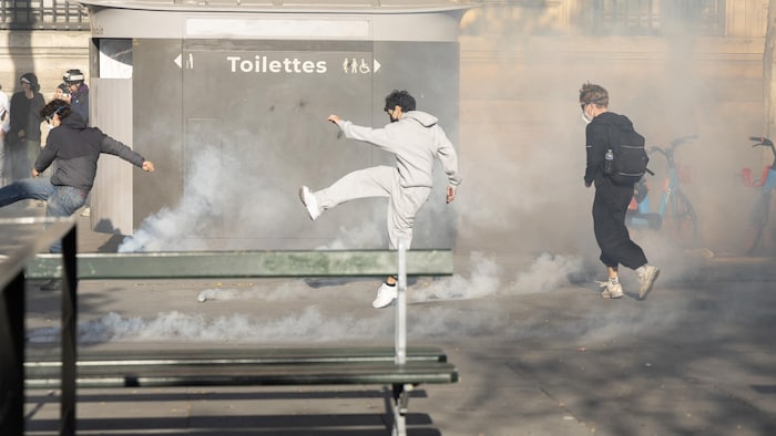 Un manifestant repousse d'un coup de pied une grenade lacrymogène sur la place de la République.