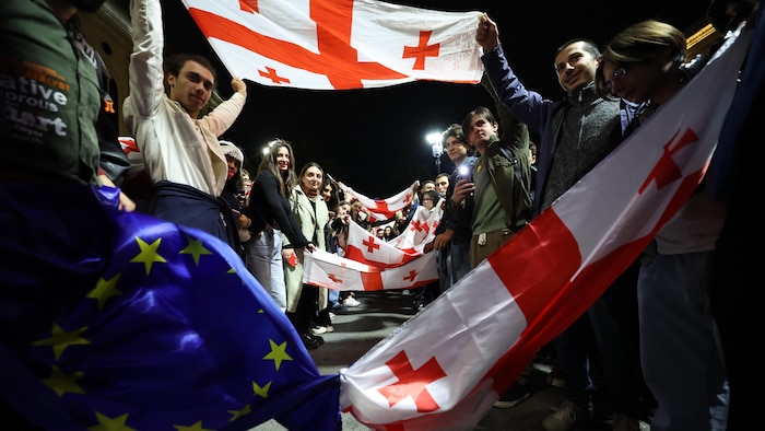 Des manifestants agitent des drapeaux de la Géorgie et de l'Union européenne.