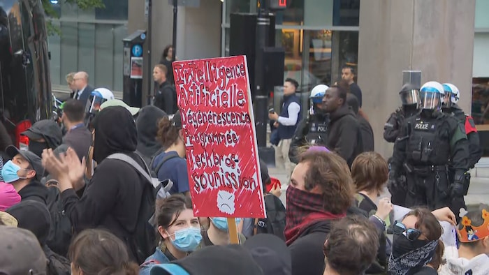 Une personne tient une pancarte.