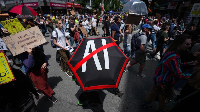 Des personnes participent à une manifestation contre l’ouverture de centres de données dédiés à l’IA, à Vancouver, le 27 juin 2026.