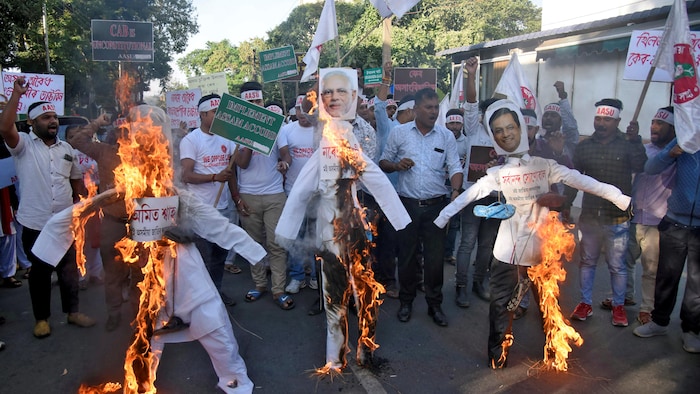 Des militants de l'Union des étudiants de l'Assam (AASU) brûlent des effigies du ministre de l'Intérieur, Amit Shah, du premier ministre, Narendra Modi, et du ministre en chef de l'Assam, Sarbananda Sonowal, lors d'une manifestation contre la nouvelle loi sur la citoyenneté.
