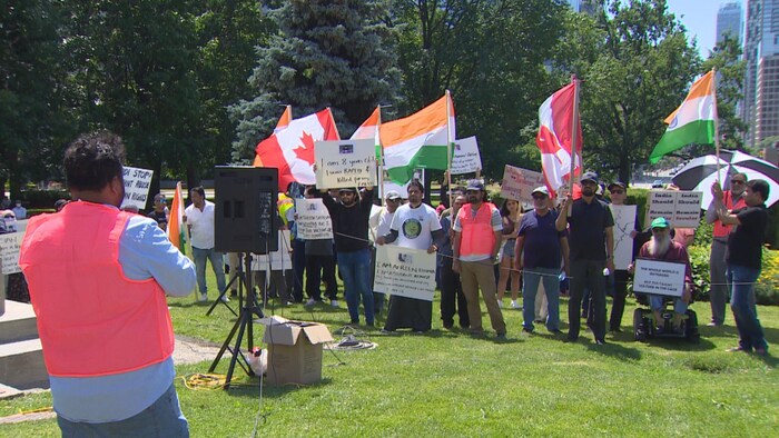 Quelques dizaines de personnes avec des pancartes et des drapeaux de l'Inde et du Canada.