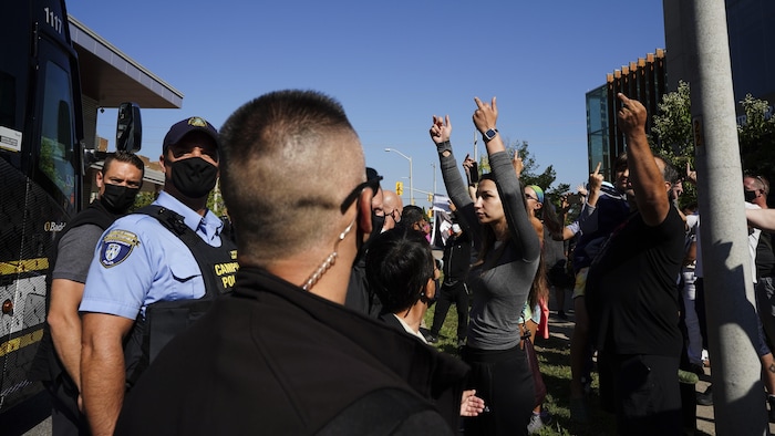 Des manifestants font des doigts d'honneur en direction de l'autobus du chef libéral.