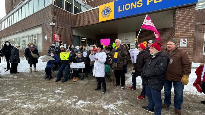 Des résidents du foyer Lions Place ont manifesté le 19 janvier 2023 devant l'immeuble de l'avenue Portage à Winnipeg. 