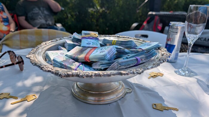 Des liasses d'argent comptant dans un plat placé sur une table.