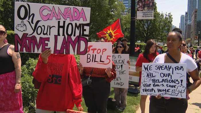 Des manifestants avec des pancartes contre la loi 5.