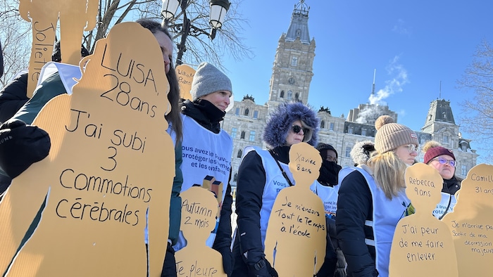 Des manifestantes tiennent des affiches en forme de silhouette. Sur chacune d'entre elles sont écrits des noms de femmes, leur âge et les actes de violence qu'elles ont subis.