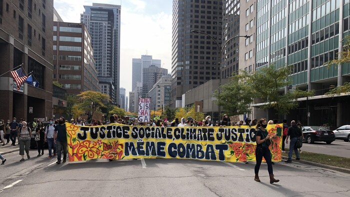 Le début de la manifestation avec une grande banderole jaune indiquant que la justice sociale et la justice climatique constituent un même combat. 