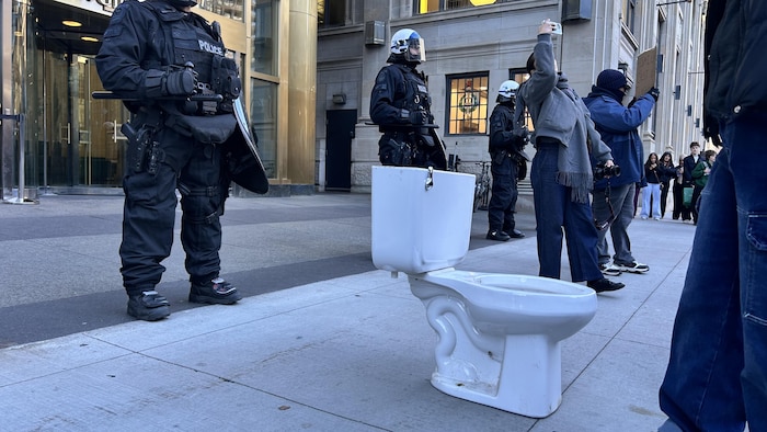 Une toilette devant des manifestants.
