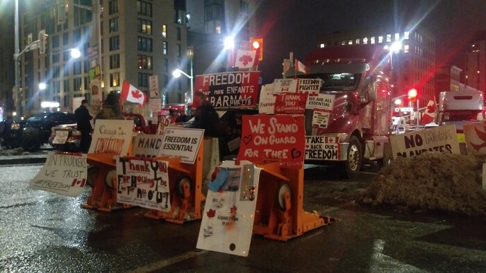 شاحنات وملصقات وأعلام كندية وأوضاء في وسط أوتاوا ليلاً.