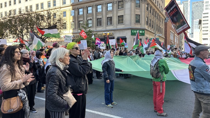 Des manifestants propalestiniens marchent dans la rue en scandant des slogans.
