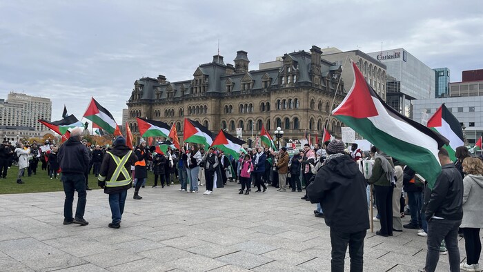 متظاهرون في أوتاوا يرفعون أعلاماً فلسطينية.