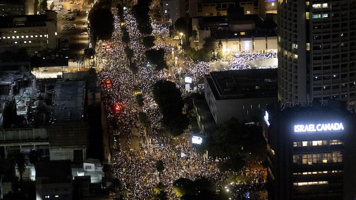 Vue aérienne montrant une rue remplie de manifestants.