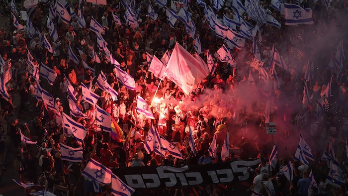 Les manifestants utilisent des fusées éclairantes lors d’un rassemblement à Tel Aviv.