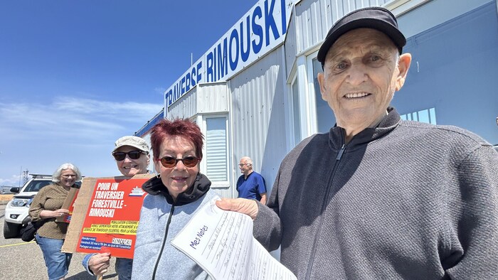 Claude Duguay manifeste au quai de Forestville accompagné d'autres personnes. 
