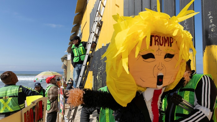 Des manifestants brandissant une piñata à l'effigie de Donald Trump lors d'une manifestation contre les mesures migratoires qu'il prévoit mettre en œuvre, à Playas Tijuana, dans la ville de Tijuana, au Mexique, le 19 janvier 2025.