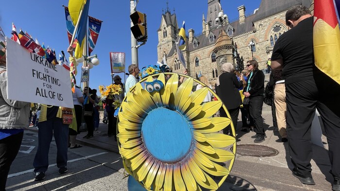 Des gens manifestent aux couleurs de l'Ukraine.