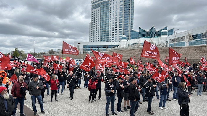 Des manifestants tiennent des drapeaux.