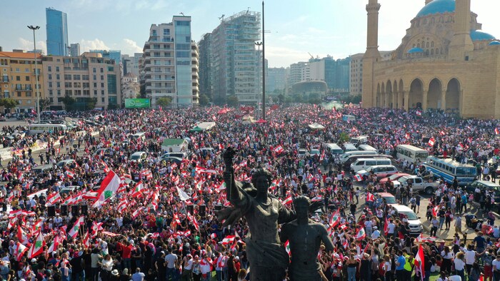 Une foule brandissant des drapeaux libanais.