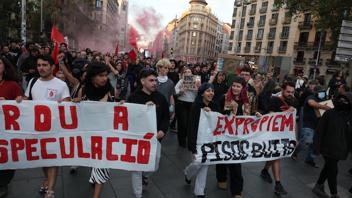 Des manifestants tiennent des pancartes.