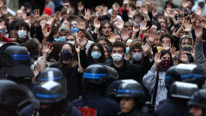 Des élèves lèvent la main devant des policiers alors qu’ils manifestent devant Sciences Po lors d’un mouvement de protestation contre la surpopulation et la dégradation des établissements scolaires, le 7 octobre 2026 à Paris, en France.