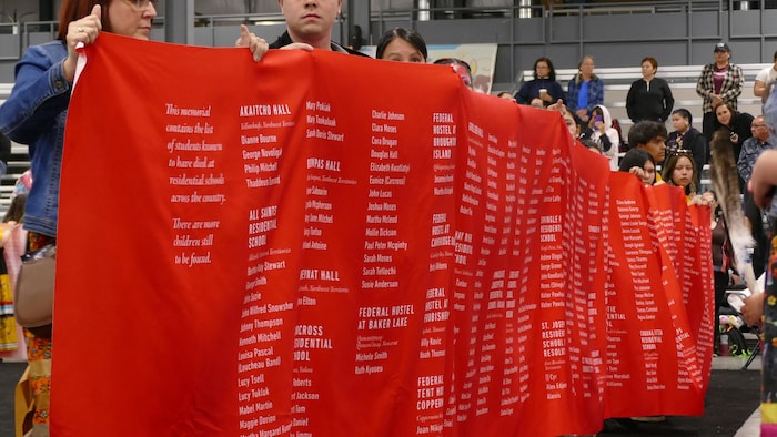 Une longue banderole portant des noms. 