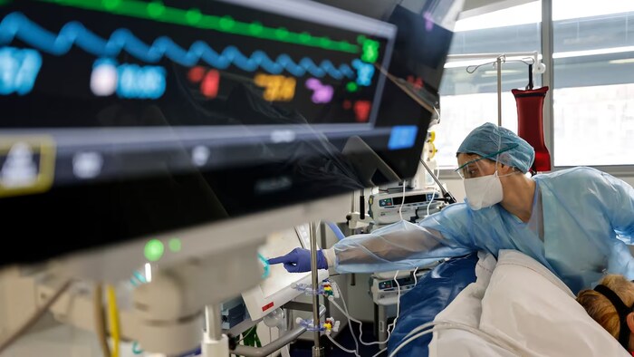 Isang nurse na nag-o-operate ng equipment sa loob ng operating room.