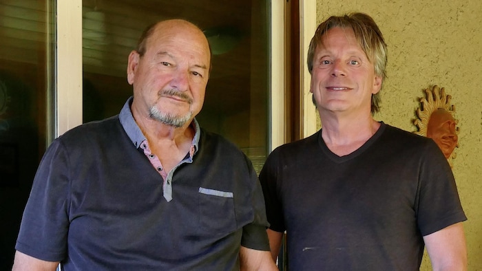Deux hommes se tiennent debout.