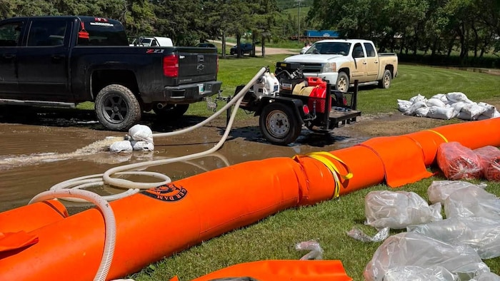 Des tubes d'eau sont installés pour retenir les crues d'une rivière.