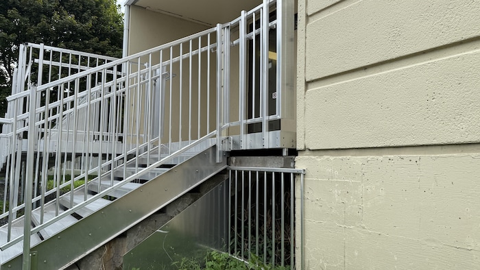 Des barreaux installés sous un escalier extérieur du Manoir du passage.