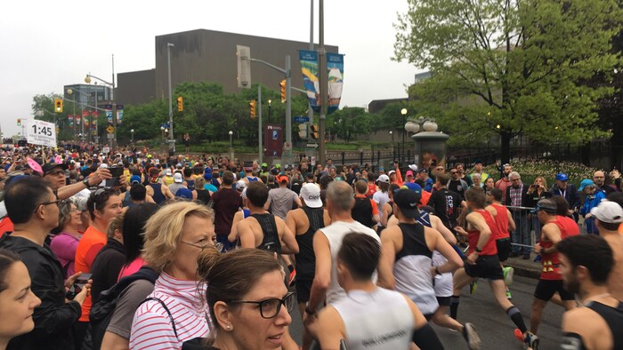 Des marathoniens passent le fil de départ, rue Elgin, à Ottawa.