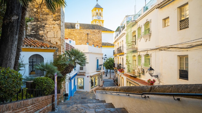 Charmante scène de rue avec façades blanches et tour de l'horloge à Marbella en Espagne.