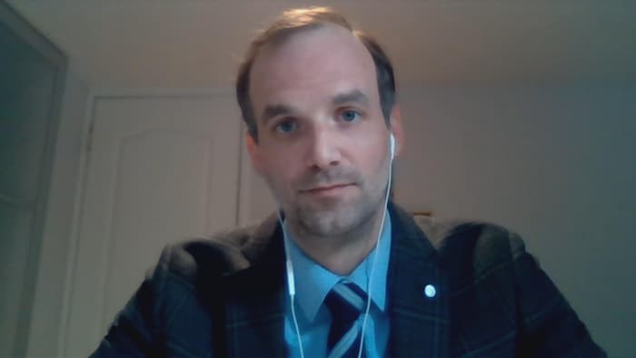 Marc-André Émard porte des écouteurs et fixe la caméra.