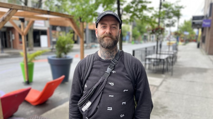 Un homme debout à l'extérieur pour se fait prendre en photo.
