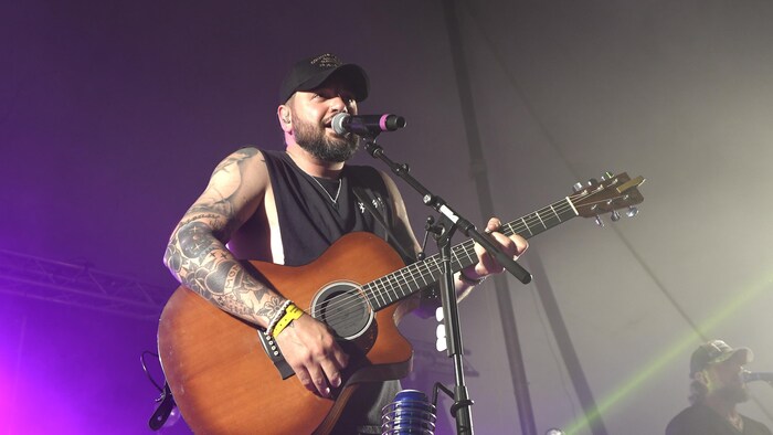 Marc-André Rioux chante, guitare à la main.