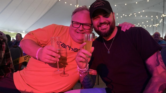 Deux hommes avec un verre à la main. 