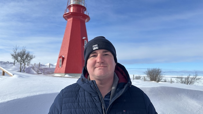 Marc-Antoine Charlebois est un homme rasé, avec une tuque et un veste, et regarde l'objectif devant le phare de La Martre.
