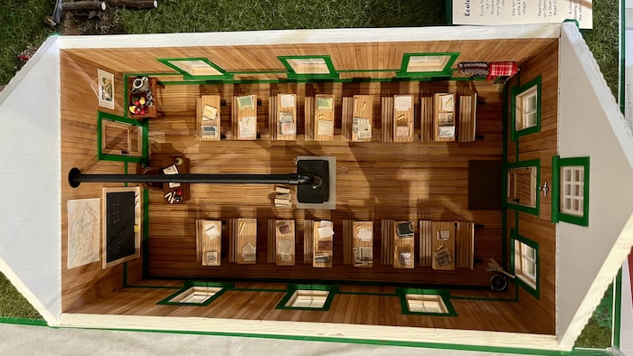 L'intérieur est en bois. Il y a un poêle à bois au centre et deux rangées de sept pupitres.