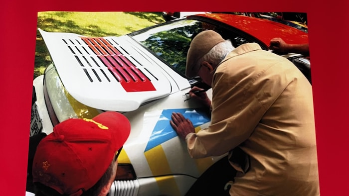 Un artiste appose sa signature sur une Porsche 911 Carrera Coupé de 1987, qu'il a peinte.