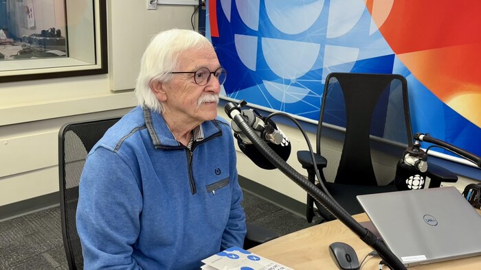 Un homme en entrevue dans un studio de radio.