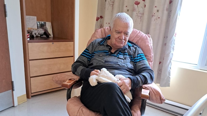 Marcel Lejeune tient un toutou dans ses mains.