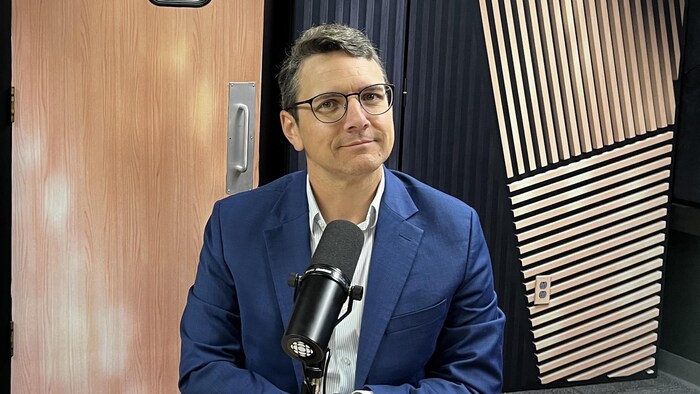 Un homme assis dans un studio de radio.