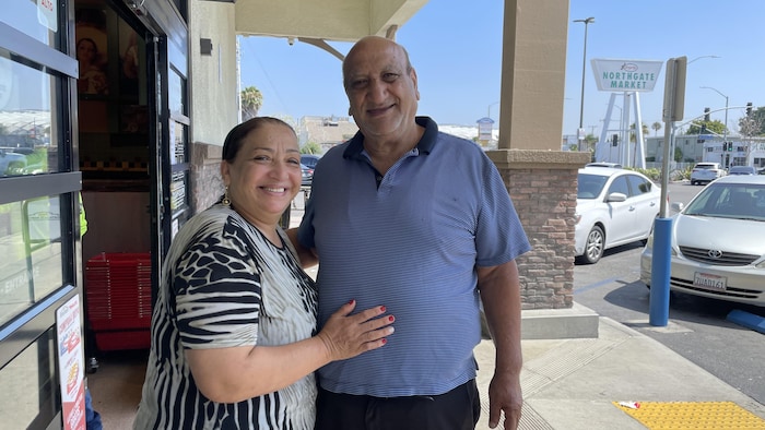 Marcelle et Georges Zarzour posant à l'entrée d'une épicerie dans Inglewood, à Los Angeles.