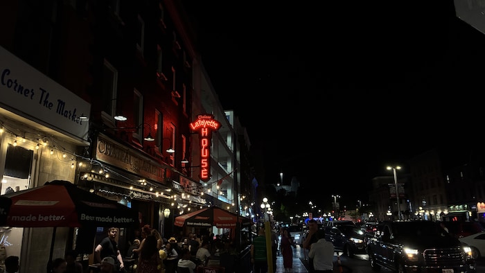 Une rue achalandée du marché By et des terrasses de bar la nuit.