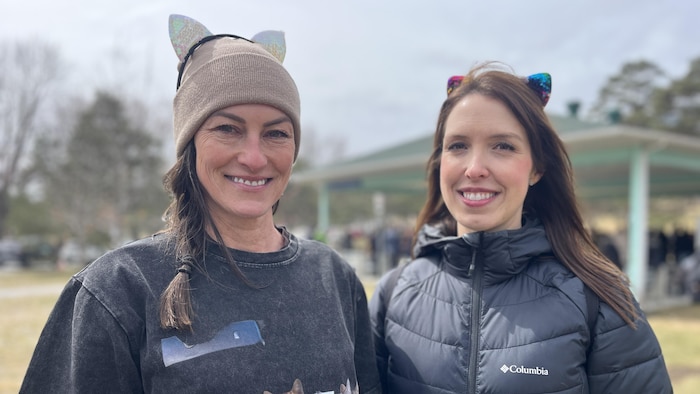 Les deux femmes sourient à la caméra.